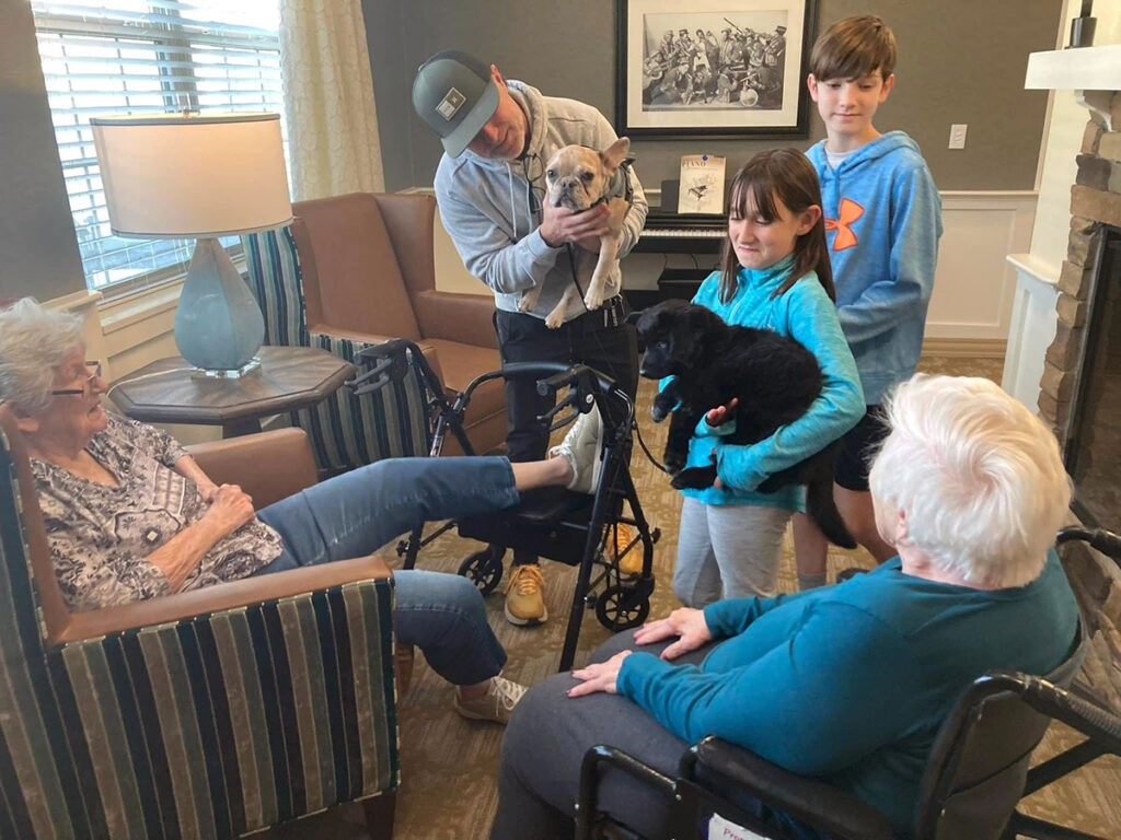 Two adorable puppies brought by a family to the Neighborhood for Memory Care residents to enjoy.
