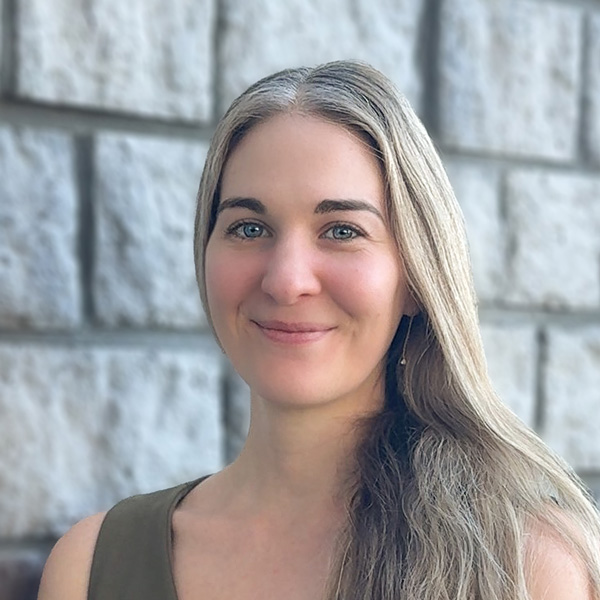 Kelsey Donyina, Memory Care Director at The Princeton Senior Living, smiling in a professional headshot with long light hair, standing in front of a light stone wall background.